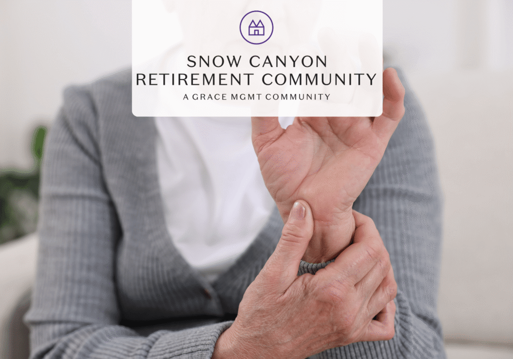 Older adult in a gray cardigan holding their wrist, with a Snow Canyon Retirement Community logo overlayed on the image.