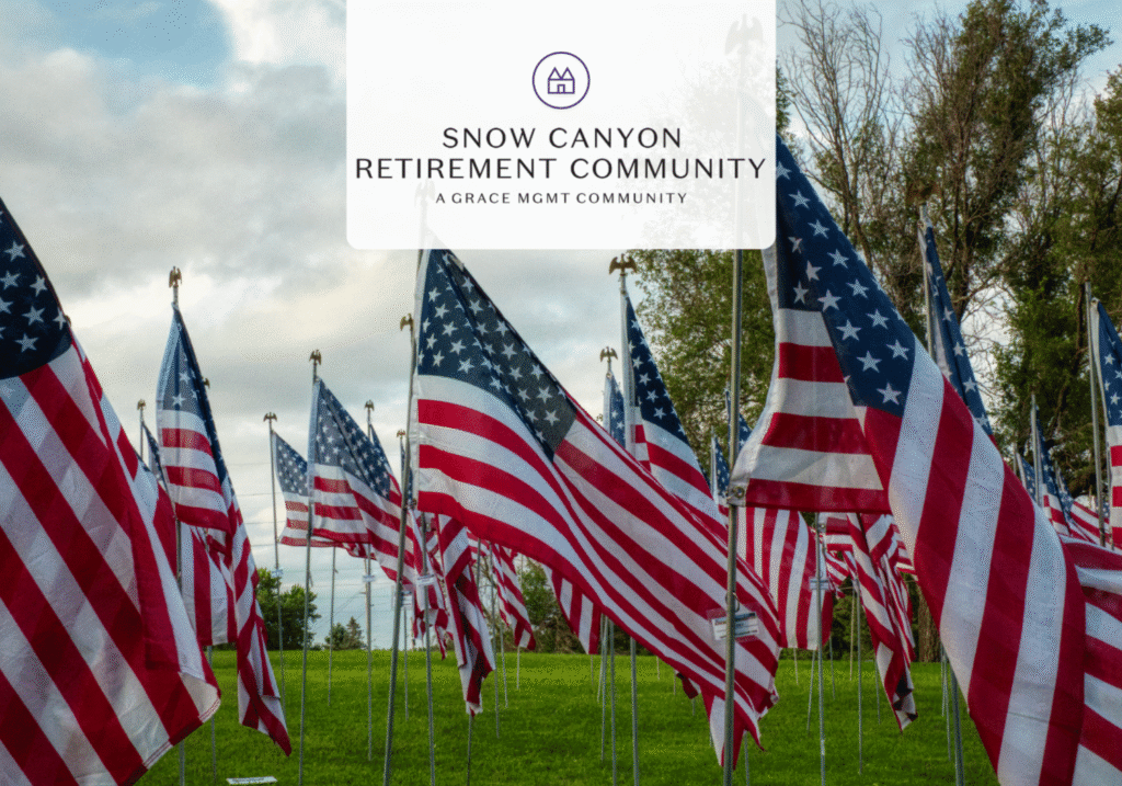 Rows of American flags in a green field with a translucent Snow Canyon Retirement Community logo overlay at the center.